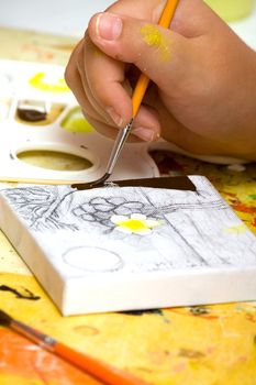 Hands of the young artist of the miniature painter drawing a picture.Work of the artist.