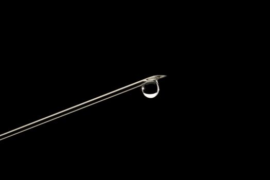 Syringe needle sharp, with a drop of water and spark, close-up, outline clear lines on a black background