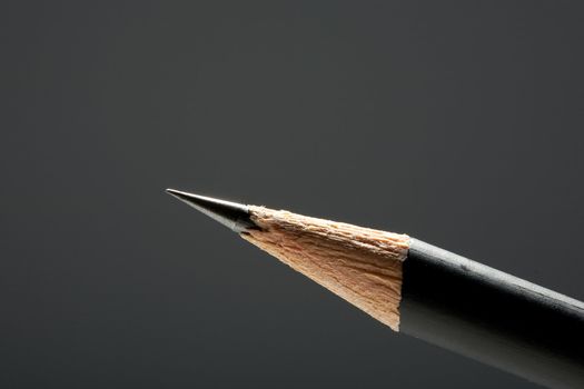 Close-up, studio, black pencil sharpened edge, is well defined on a grey background