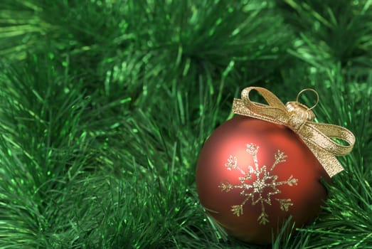 Red christmas ball on the green tinsel. aRGB.