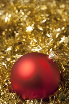 Red christmas ball on the golden tinsel. aRGB.