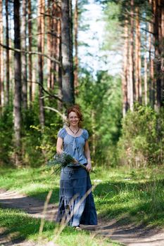 Red-haired women walking on path in the wood