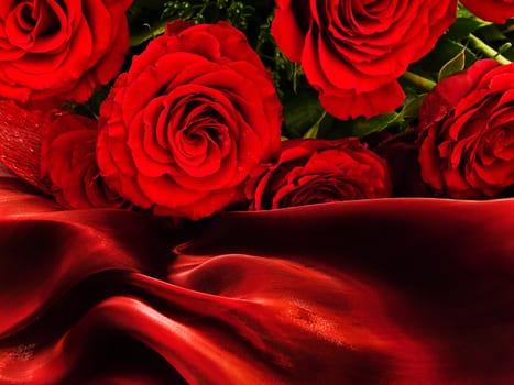 Red beautiful roses on a vinous silk fabric