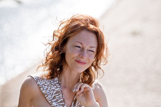 Portrait of red-haired adult women in dune at the sea