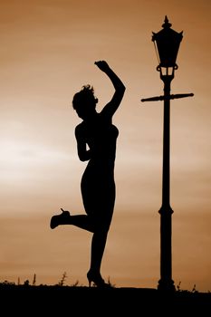 Silhouette of women dancing at sunset by lantern