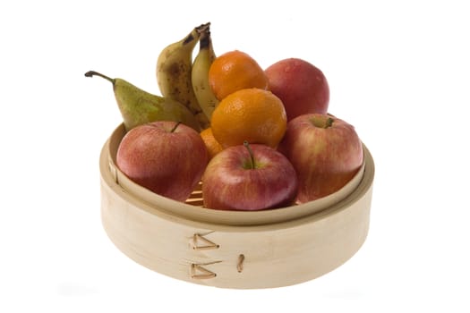 Bamboo steamer with apples, pears, tangerines and bananas,.