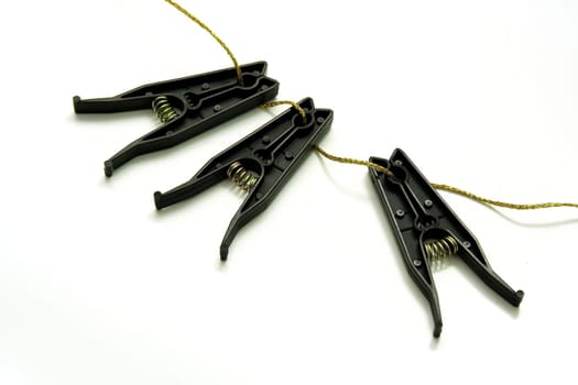 Black plastic linen clothespins on white background