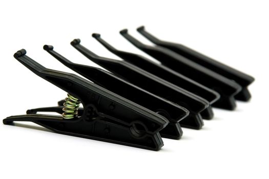 Black plastic linen clothespins on white background