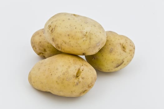 four young potatoes with gentle shadow on natural background