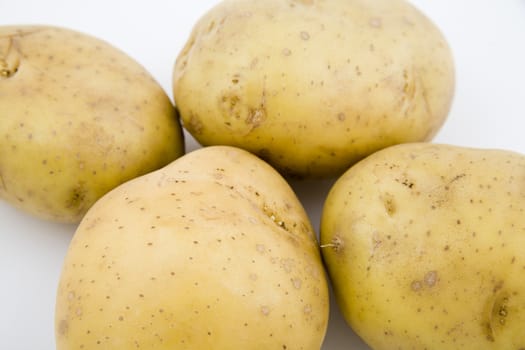 four young potatoes with gentle shadow on natural background