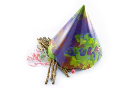 Salty brown tasty pretzels with cone shaped party hat and streamers on a reflective white background