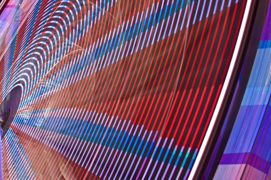 motion blur of a colorful ferris wheel at night