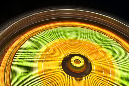 motion blur of a colorful ferris wheel at night