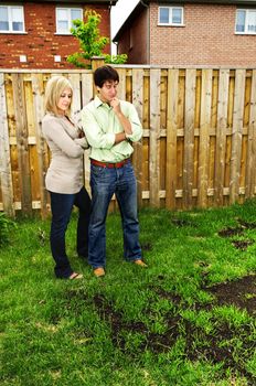 Young couple worried about growing lawn in backyard of new home