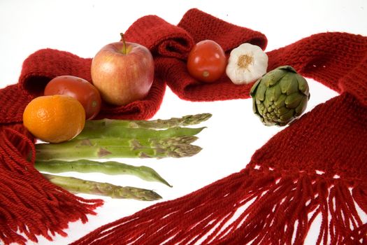 A scarf , fruits, vegetables  representing health care through balanced diet and being wrapped warmly.