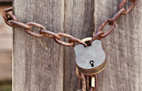 old lock and chain around wooden fence