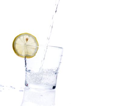glass of liquid with lemon isolated over a withe background