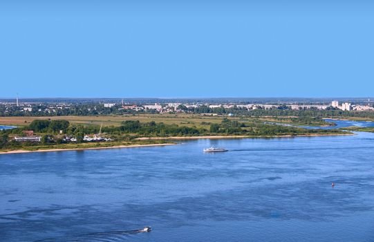 The river with two swimming means against an industrial city