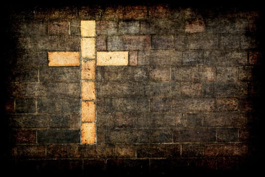 grungy cross of christ built into a brick wall as background