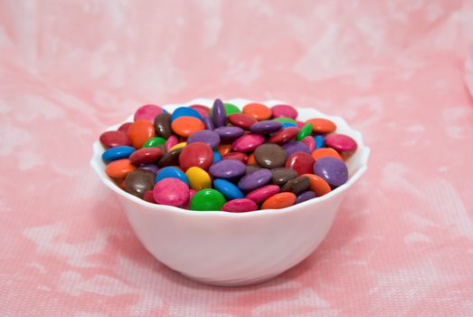 bowl of smarties on pink background