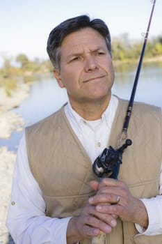 Man Standing By A River With A Fishing Pole