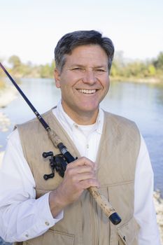 Man Standing By A River With A Fishing Pole