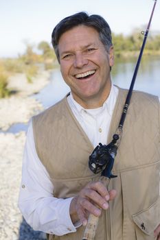 Man Standing By A River With A Fishing Pole