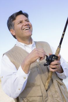 Man Standing By A River With A Fishing Pole