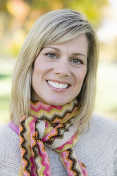 Portrait of a Pretty Blond Woman in a Scarf and Sweater Smiling To Camera
