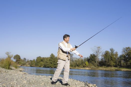 Man Standing By A River With A Fishing Pole