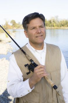 Man Standing By A River With A Fishing Pole