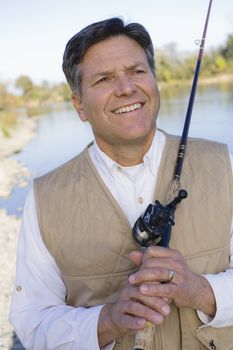 Man Standing By A River With A Fishing Pole