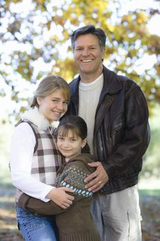 Portrait of a Father and Two Daughters Together in a Park