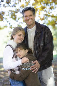 Portrait of a Father and Two Daughters Together in a Park