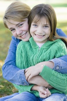 Portrait of Two Sisters Holding Each Other in a Park