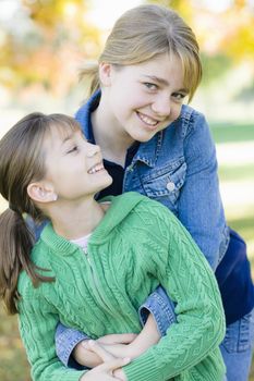 Portrait of Two Sisters Holding Each Other in a Park