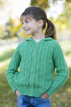 Portrait of a Cute Young Girl Standing in a Park