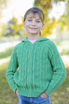 Portrait of a Cute Young Girl Standing in a Park