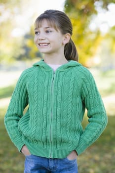 Portrait of a Cute Young Girl Standing in a Park