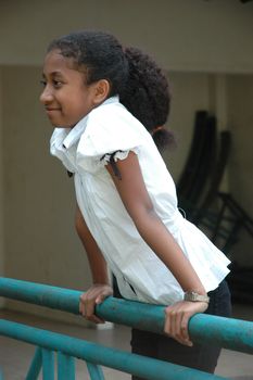 little asian girl stand up beside the fench