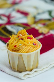 Cupcake decorated with yellow frosting and sugar