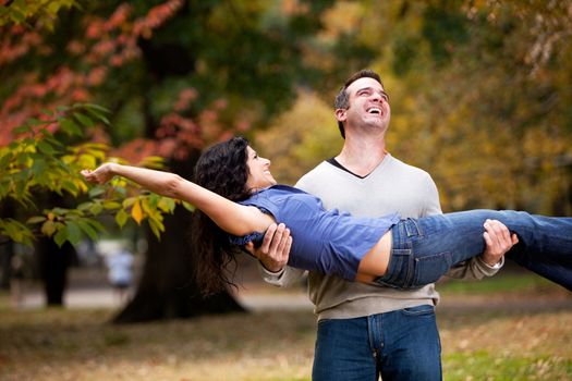 A playful couple - man holding woman in the park