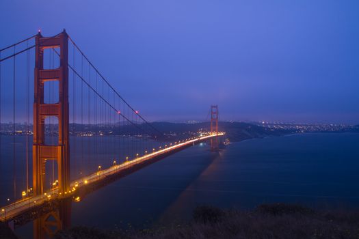 Golden Gate Bridge sunset evening with lights of San Francisco California in background