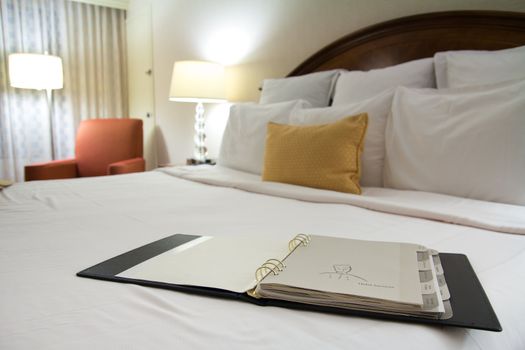 Hotel room service menu book on bed