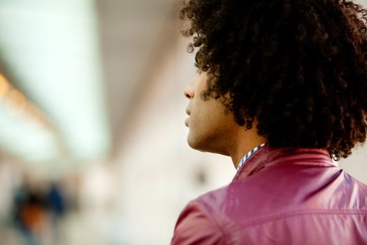 An African American man with afro looking away from the camera