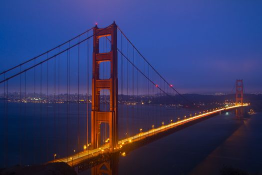 Golden Gate Bridge sunset evening with lights of San Francisco California in background