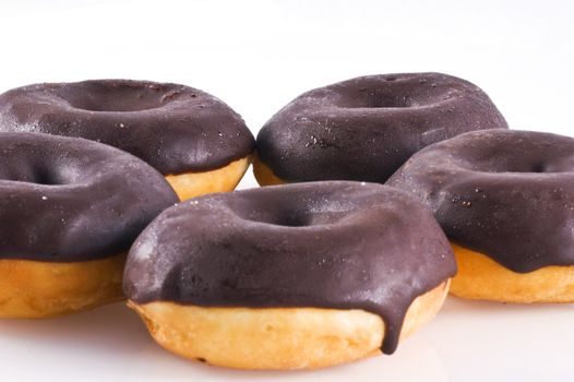 Close up of some chocolate donuts, isolated on white.