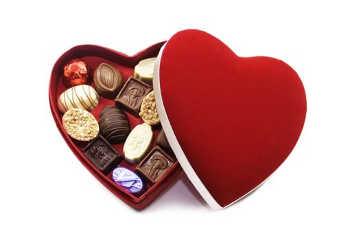 A heart shaped box of chocolates with a red felt lid. Set on an isolated white background.