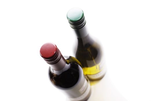 Two bottles of wine. one red, one white. Image from above with forshortened perspective and soft focus. Set on an isolated white background in a landscape format. Both bottles with screw tops.