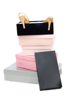 Pile of boxes and woman high-heeled shoes over white